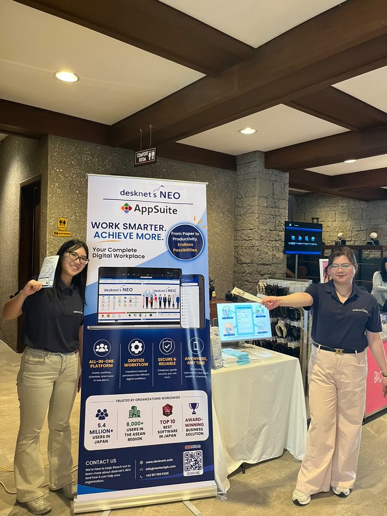 Two desknet's NEO team members beside the event display